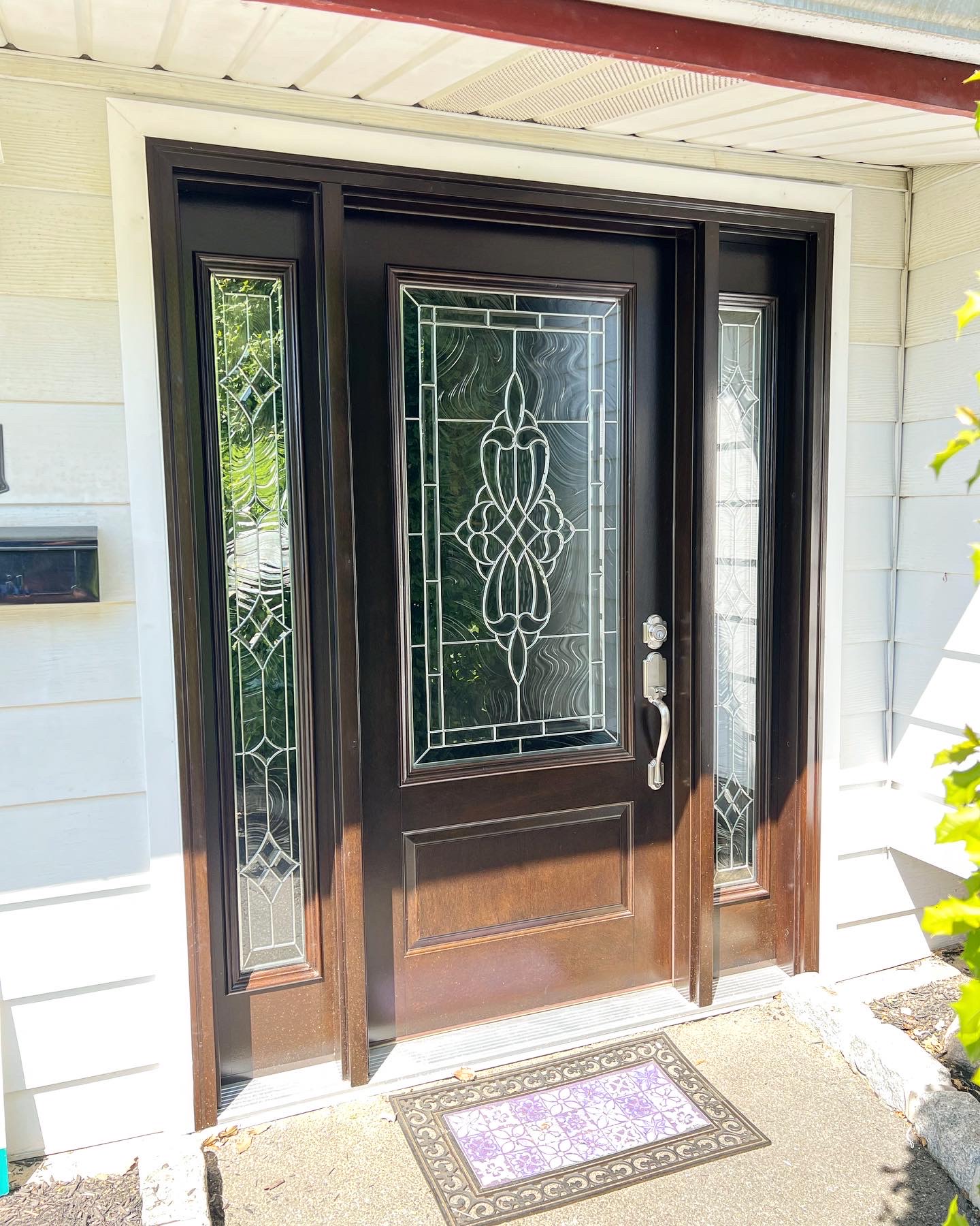 Dark wooden front door with leaded glass panels and matching sidelights on residential home