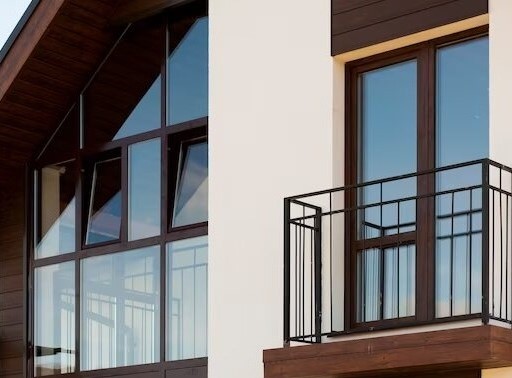 Modern residential building with large windows and metal-railed balcony