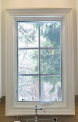 Modern white-framed window with six panes showing green outdoor view