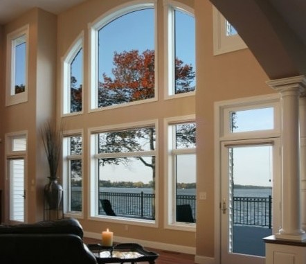 Modern home interior with expansive waterfront windows and natural autumn views